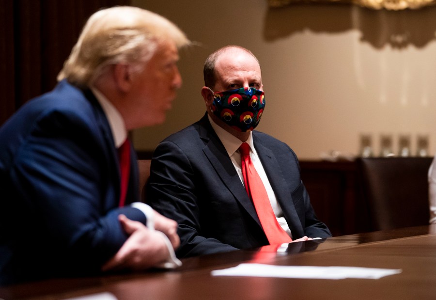 Colorado Governor Jared Polis wears a face mask as U.S. President Donald Trump makes remarks during a meeting in the Cabinet Room of the White House, May 13, 2020 in Washington, DC. (Photo by Doug Mills-Pool/Getty Images)