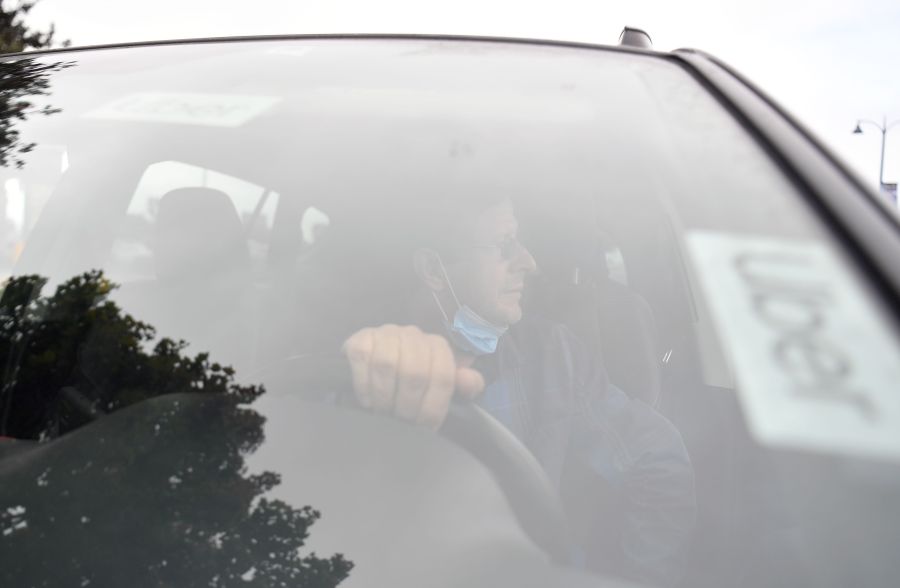 An Uber driver speaks to a reporter about why he supports a no on Proposition 22 vote in Oakland on Oct. 9, 2020. (Josh Edelson / AFP / Getty Images)