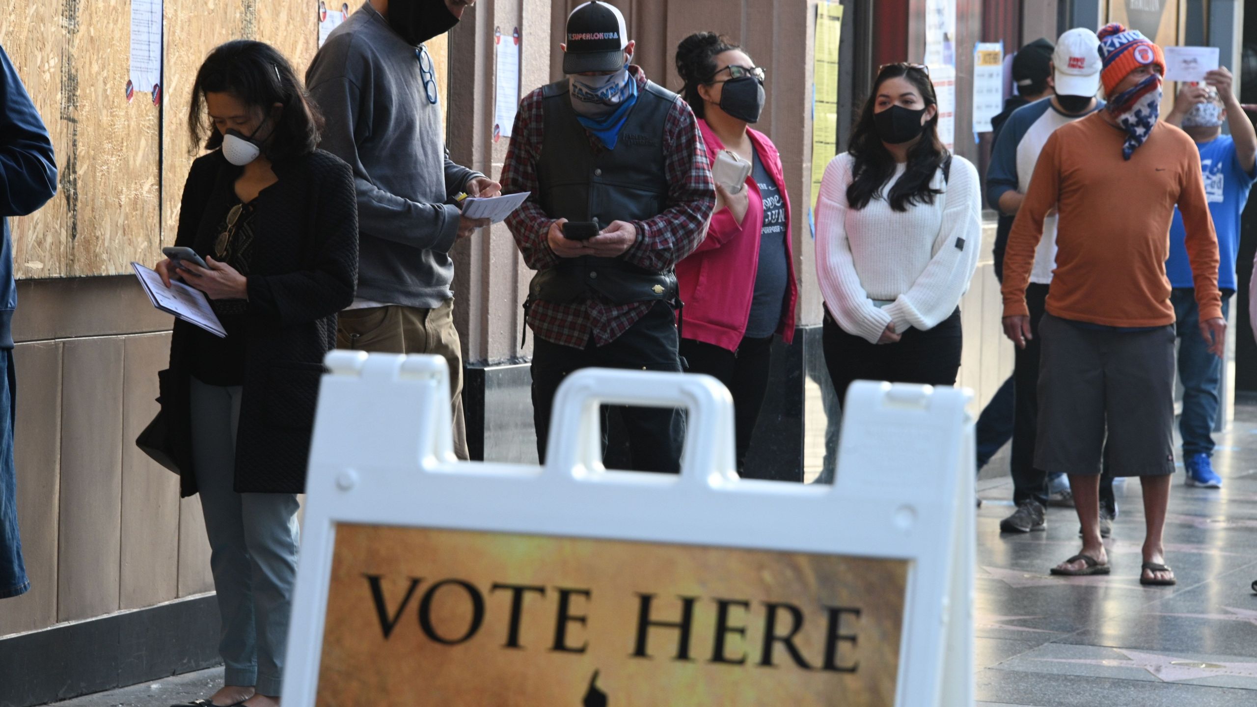 People wait in line for the vote center to open at the Pantages Theatre on the Hollywood Walk of Fame to cast their ballots on Nov. 3, 2020. (ROBYN BECK/AFP via Getty Images)