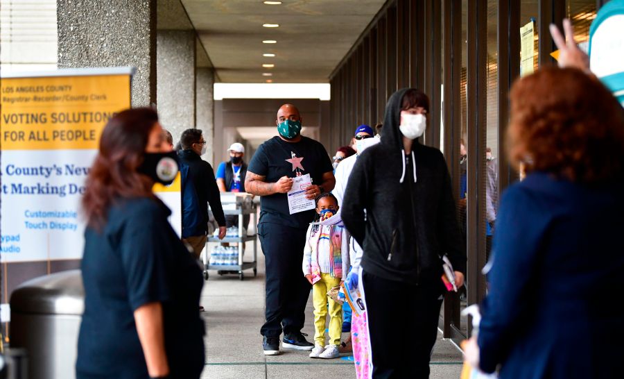 Voters wear face-coverings while waiting in line to vote for the 2020 US elections at the Los Angeles County Registrar in Norwalk on Nov. 3, 2020. (Frederic J. Brown / AFP / Getty Images)