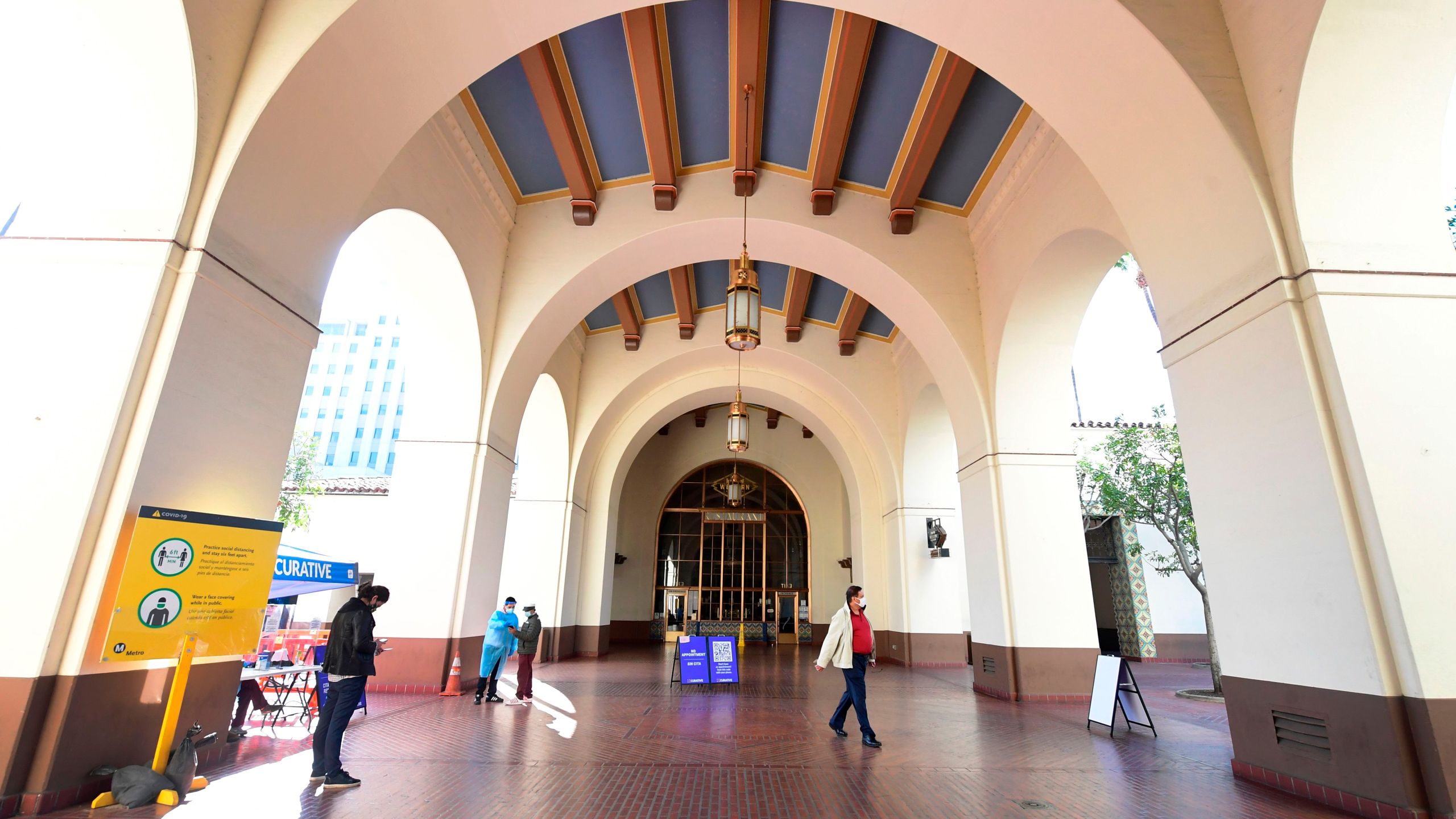 Testing Center Specialists fully dressed in personal protective equipment assist people arriving for a coronavirus test at Union Station in Los Angeles on Nov. 13, 2020. (FREDERIC J. BROWN/AFP via Getty Images)