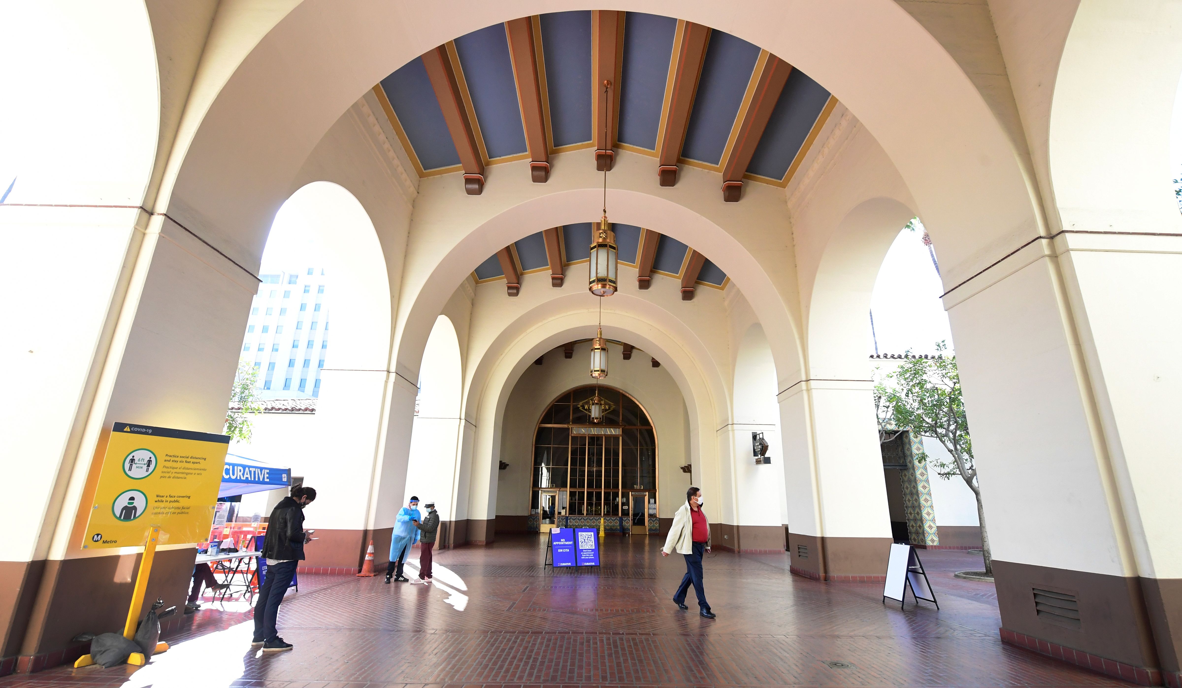 Testing Center Specialists fully dressed in personal protective equipment assist people arriving for a coronavirus test at Union Station in Los Angeles on Nov. 13, 2020. (FREDERIC J. BROWN/AFP via Getty Images)