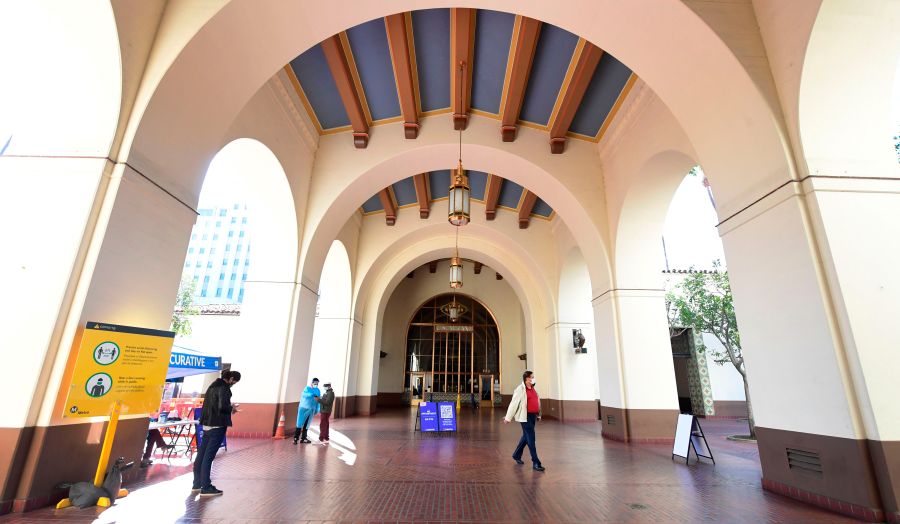 Testing Center Specialists fully dressed in personal protective equipment assist people arriving for a coronavirus test at Union Station in Los Angeles on Nov. 13, 2020. (FREDERIC J. BROWN/AFP via Getty Images)