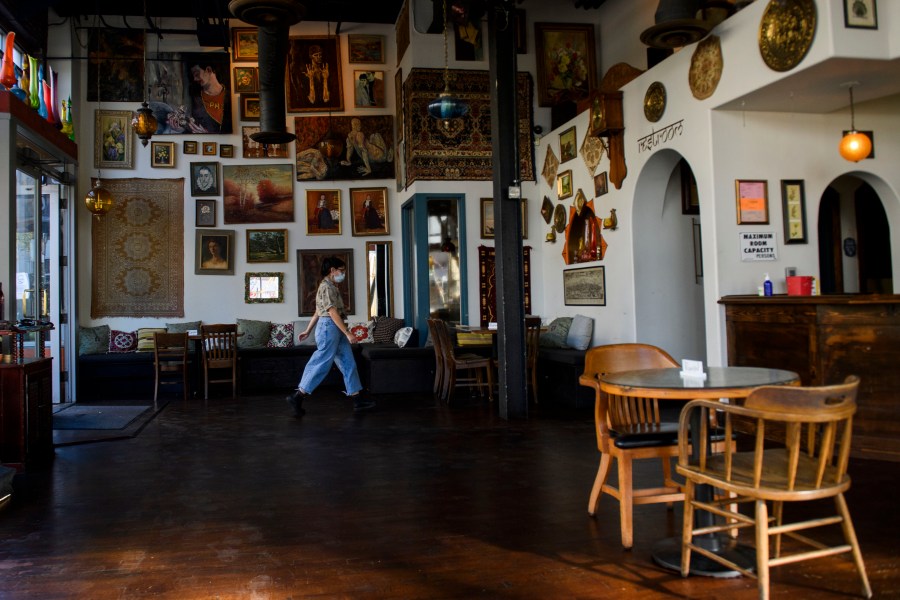 Rachel Thorlund, manager at The Den Cafe, walks past a closed table following reimposed restrictions on indoor dining in Orange County due to Covid-19 in Santa Ana, California, November 17, 2020. (Patrick T. Fallon/AFP via Getty Images)