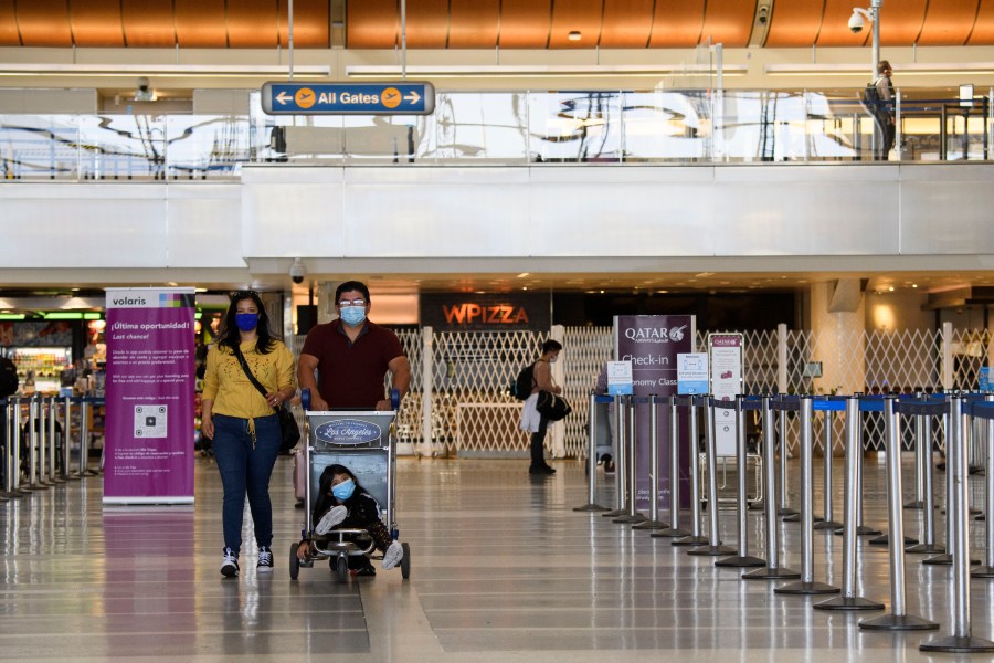 Travelers walk past flight check-in counters inside the Tom Bradley international Terminal at Los Angeles International Airport (LAX) in Los Angeles, California, Nov. 18, 2020. (PATRICK FALLON/AFP via Getty Images)