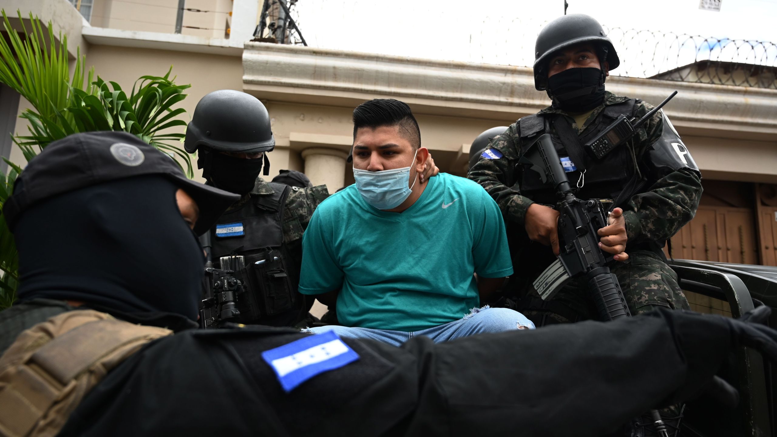 Members of the National Anti Maras and Gangs Force (FNAMP) arrest Jose Alejandro Nunez Cruz (C), alleged administrator of the criminal gang Mara Salvatrucha 13 (MS-13), at an exclusive residential area in Tegucigalpa, on November 26, 2020. (Orlando Sierra/AFP via Getty Images)