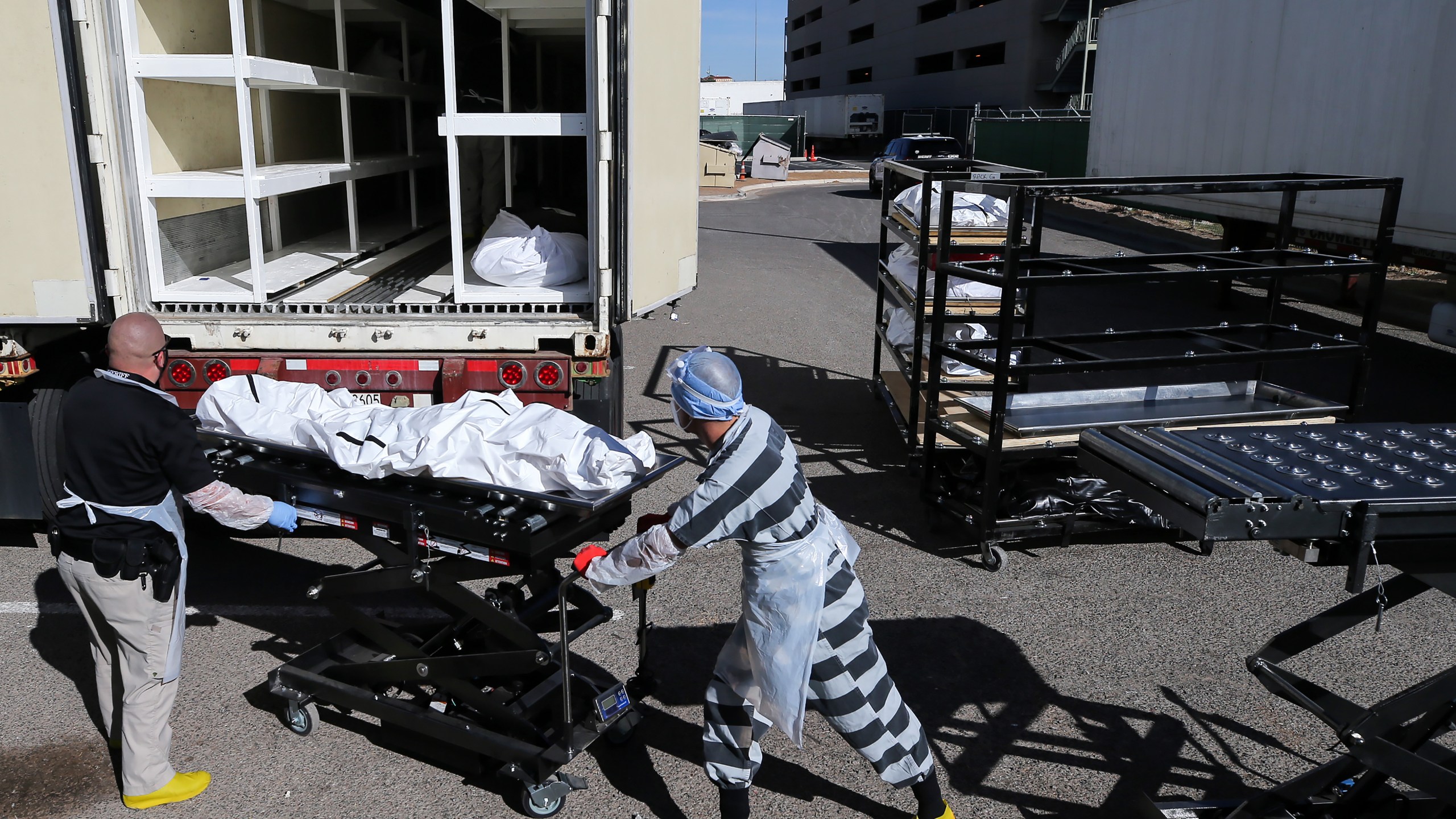 An inmate from El Paso County detention facility works while loading bodies wrapped in plastic into a refrigerated temporary morgue trailer in a parking lot of the El Paso County Medical Examiner's office on Nov. 17, 2020 in El Paso, Texas. (Mario Tama/Getty Images)