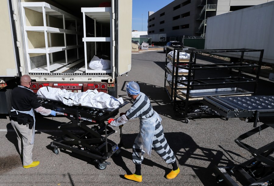 An inmate from El Paso County detention facility works while loading bodies wrapped in plastic into a refrigerated temporary morgue trailer in a parking lot of the El Paso County Medical Examiner's office on Nov. 17, 2020 in El Paso, Texas. (Mario Tama/Getty Images)