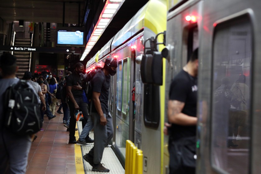 People enter a train at the 7th Street Metro Center in Los Angeles. Los Angeles County residents are urged to stay at home as much as possible as the coronavirus surges.(Dania Maxwell / Los Angeles Times)