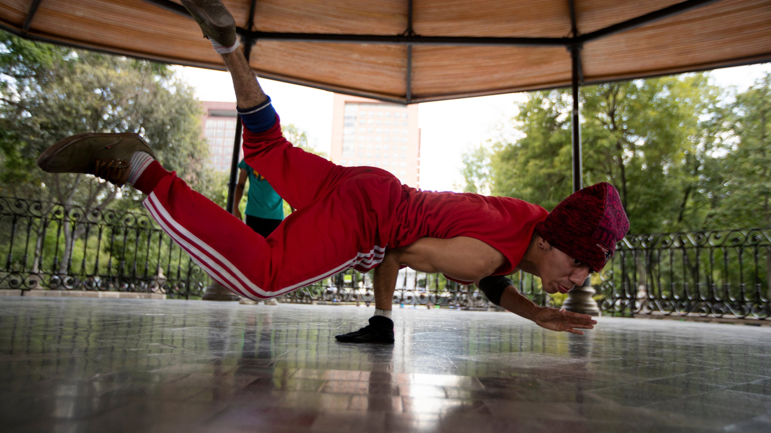 Carlos Cruz, a breakdancer, practices at a kiosk in Alameda park after being closed off to the public for nearly five months due to the new coronavirus pandemic, in Mexico City, Tuesday, Aug. 18, 2020. (AP Photo/Fernando Llano)