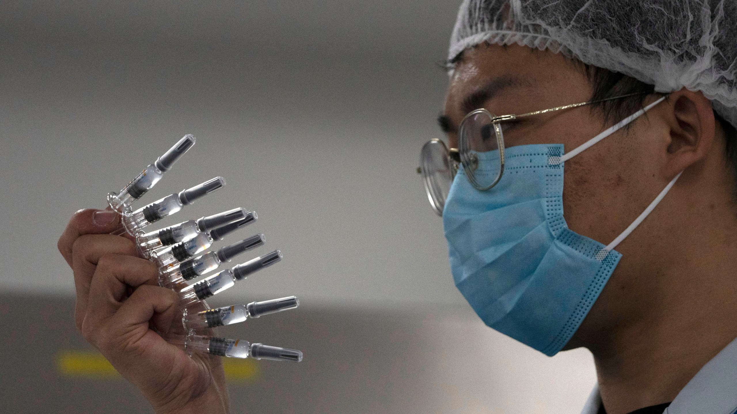 In this Sept. 24, 2020, file photo, an employee manually inspects syringes of the SARS CoV-2 Vaccine for COVID-19 produced by Sinovac at its factory in Beijing. (Ng Han Guan/AP Photo)