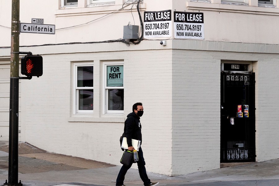 A pedestrian passes under for rent and for lease signs in San Francisco on Oct. 21, 2020. (Noah Berger/Associated Press)