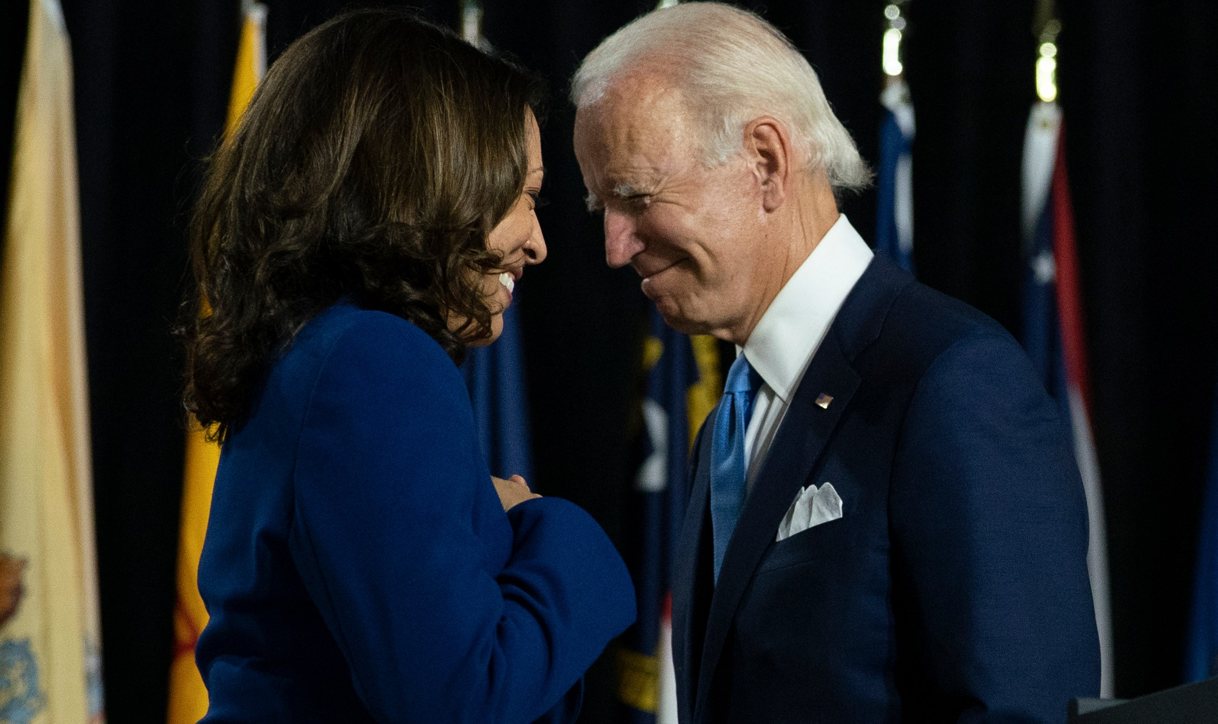 In this Aug. 12, 2020, file photo, Democratic presidential candidate former Vice President Joe Biden and his running mate Sen. Kamala Harris pass each other as Harris moves to the podium to speak during a campaign event at Alexis Dupont High School in Wilmington, Del. (Carolyn Kaster / Associated Press)