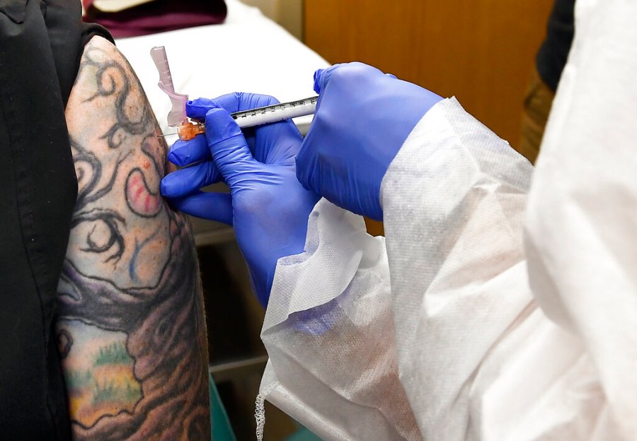 In this July 27, 2020, file photo, Nurse Kathe Olmstead, right, gives volunteer Melissa Harting, of Harpersville, N.Y., an injection as a study of a possible COVID-19 vaccine, developed by the National Institutes of Health and Moderna Inc., gets underway in Binghamton, N.Y. (AP Photo/Hans Pennink, File)