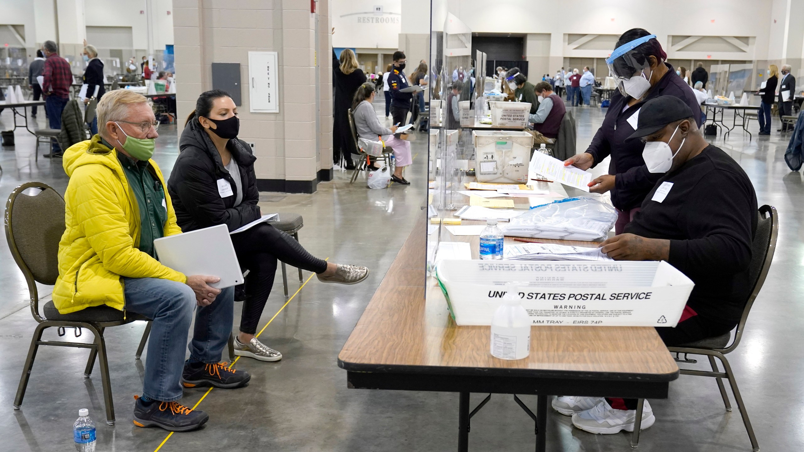 In this Nov. 20, 2020, file photo, election workers, right, verify ballots as recount observers, left, watch during a Milwaukee hand recount of presidential votes at the Wisconsin Center in Milwaukee. (Nam Y. Huh/Associated Press)