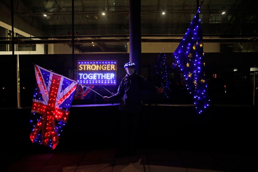 A pro-European Union membership supporter protests with illuminated European and Union flags outside Brexit trade negotiations between Britain and the EU at the Conference Centre in London, Friday, Dec. 4, 2020. (Matt Dunham/AP Photo)