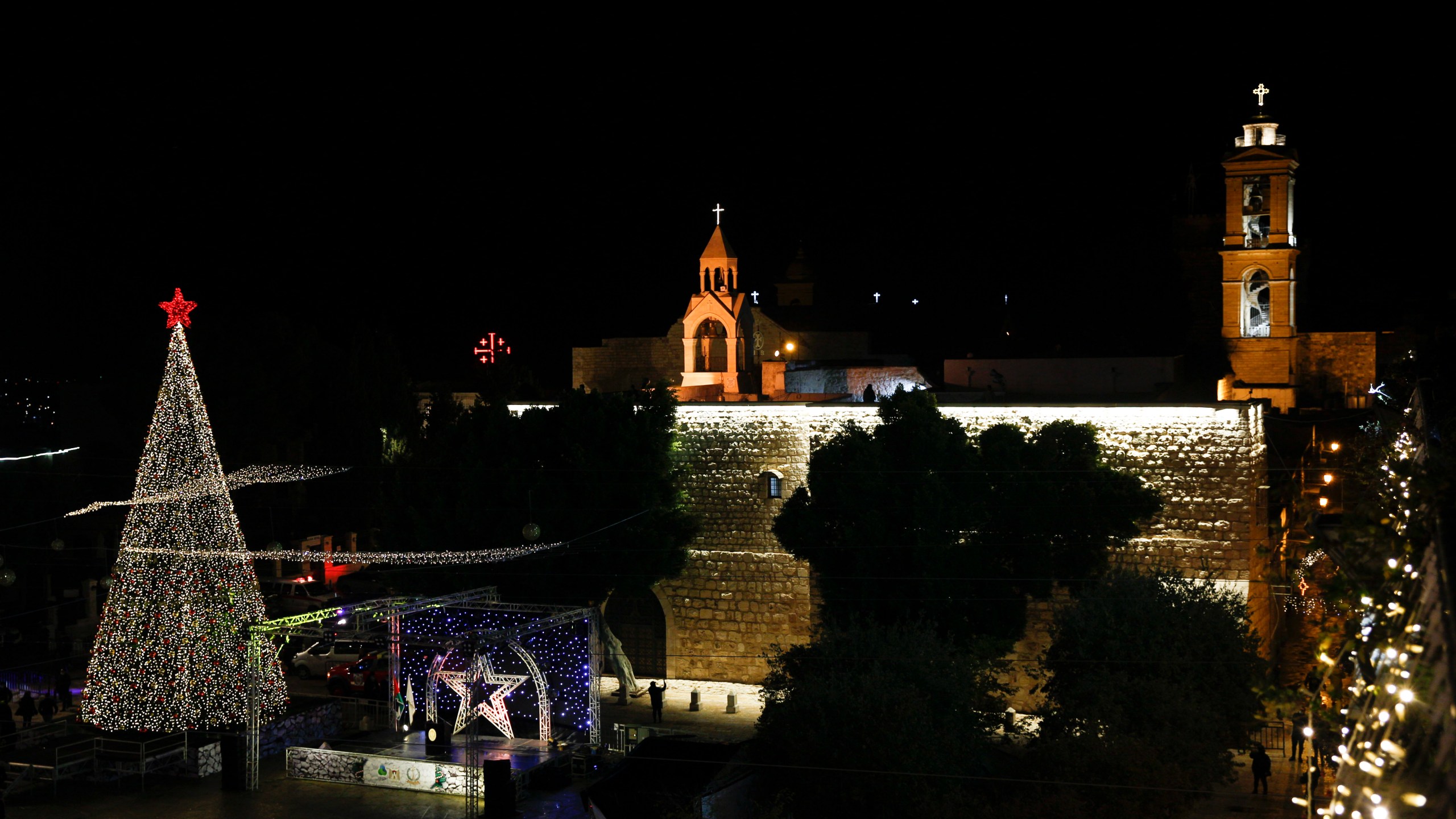 Christmas tree is lit outside the Church of the Nativity, traditionally believed by Christians to be the birthplace of Jesus Christ in the West Bank city of Bethlehem, Saturday, Dec. 5, 2020. (AP Photo/Majdi Mohammed)