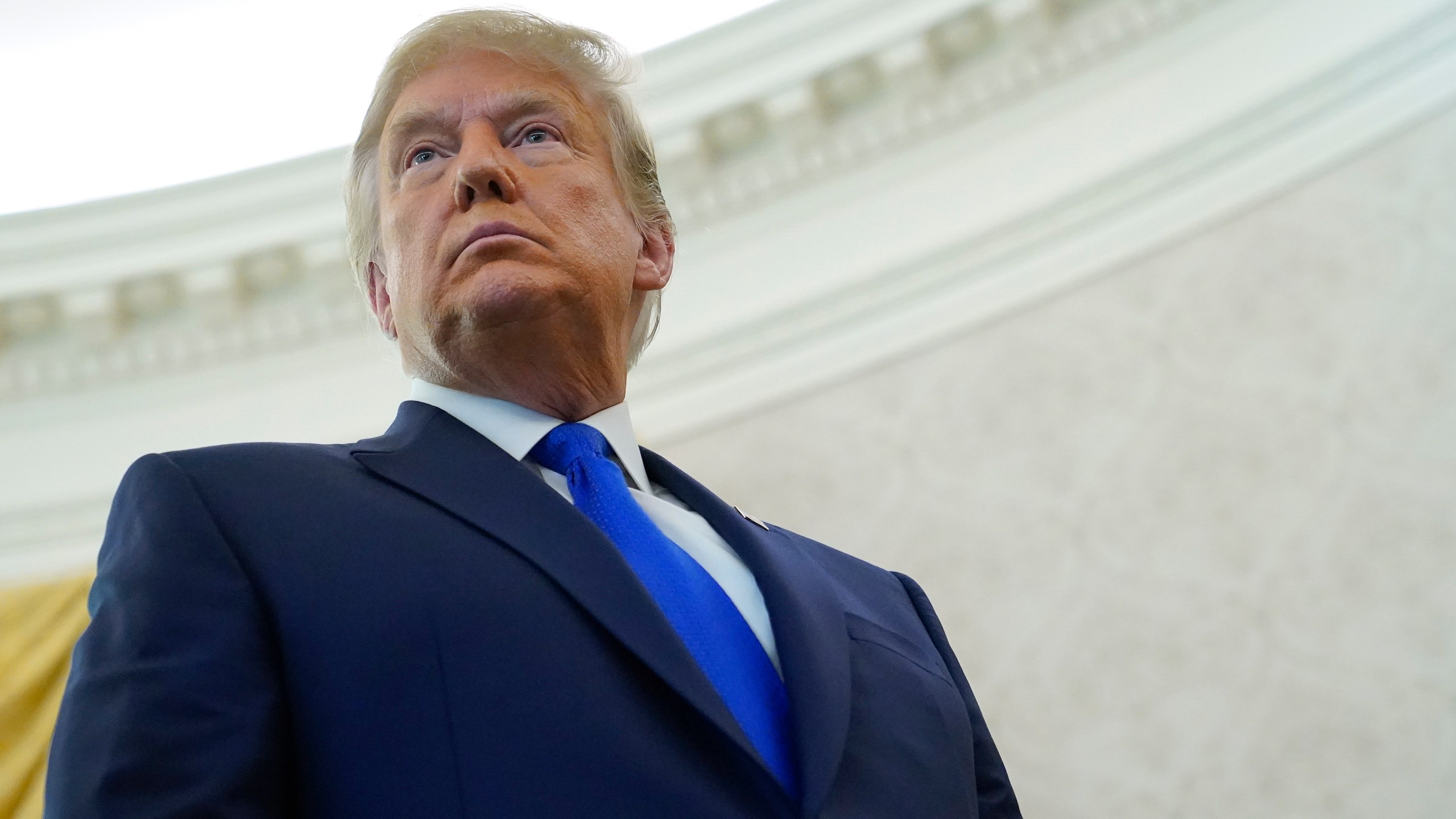 President Donald Trump listens to a reporter's question after awarding the Presidential Medal of Freedom, the highest civilian honor, to Olympic gold medalist and former University of Iowa wrestling coach Dan Gable on Dec. 7, 2020. (Patrick Semansky/Associated Press)