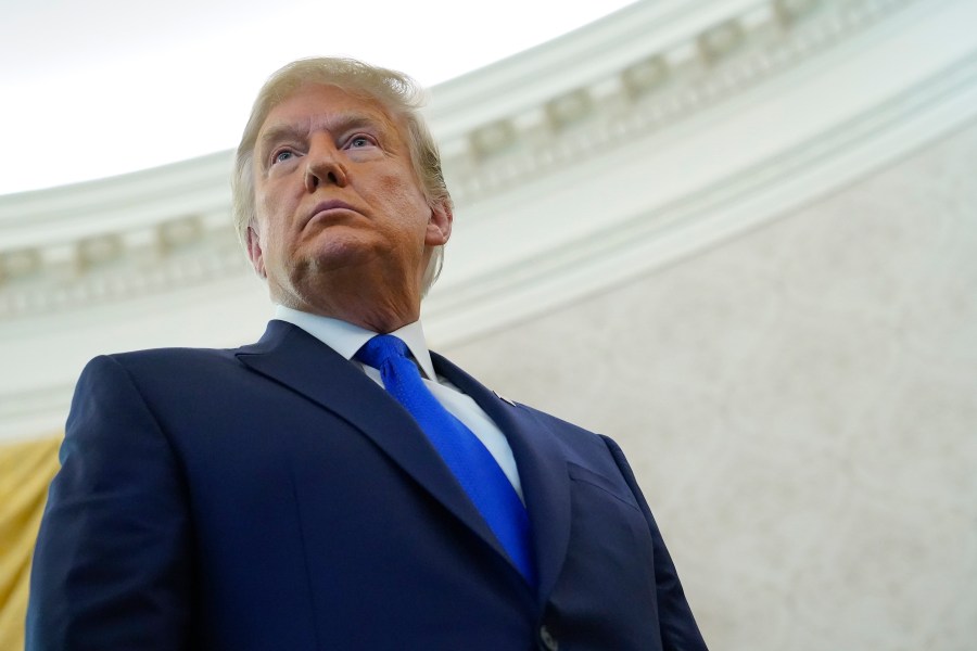 President Donald Trump listens to a reporter's question after awarding the Presidential Medal of Freedom, the highest civilian honor, to Olympic gold medalist and former University of Iowa wrestling coach Dan Gable on Dec. 7, 2020. (Patrick Semansky/Associated Press)