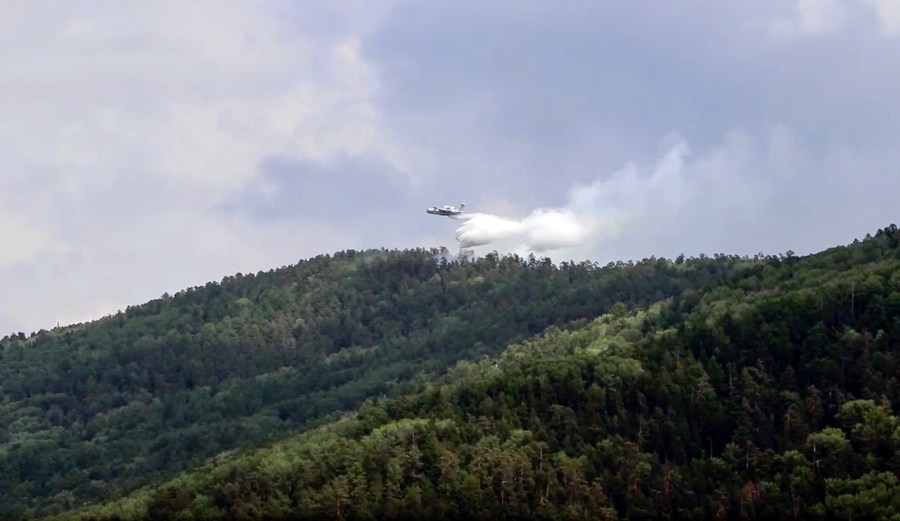 In this July 10, 2020, file image taken from video provided by Russian Emergency Ministry, a multipurpose amphibious aircraft releases water to extinguish a fire in the Trans-Baikal National Park in Buryatia, southern Siberia, Russia. The National Oceanic and Atmospheric Administration’s annual Arctic Report Card, released on Tuesday, Dec. 8, 2020, shows how warming temperatures in the Arctic are transforming the region's geography and ecosystems. (Russian Emergency Ministry Press Service via AP, File)