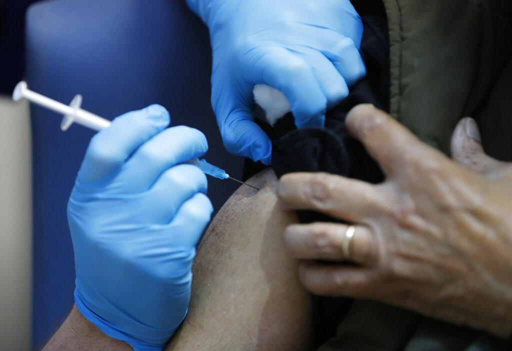 A nurse administers the Pfizer-BioNTech COVID-19 vaccine at Guy's Hospital in London, Tuesday, Dec. 8, 2020. (AP Photo/Frank Augstein, Pool)