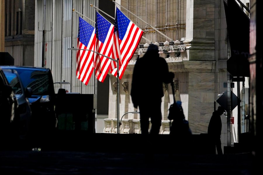 In this Oct. 14, 2020 file photo, pedestrians pass the New York Stock Exchange in New York. Stocks are rising in early Monday, Dec. 14 trading on Wall Street, as the country’s first vaccinations against COVID-19 have the end of the pandemic slowly materializing into hazy sight. (AP Photo/Frank Franklin II, File)