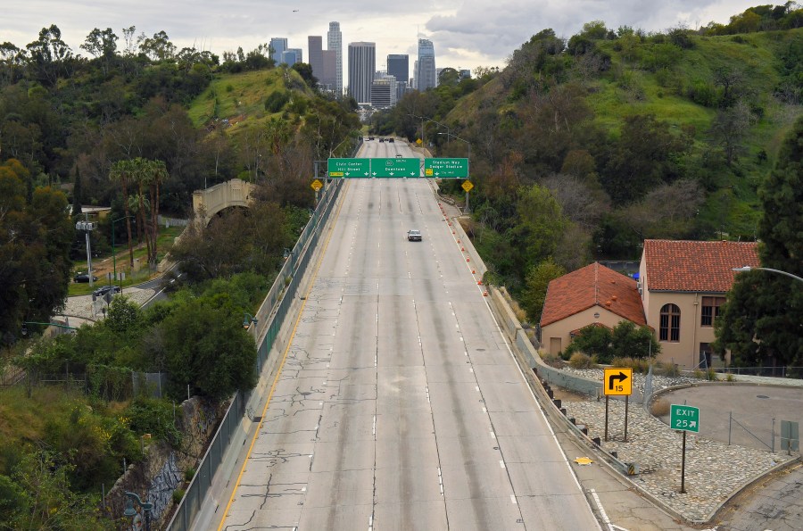 In this Friday, March 20, 2020 file photo, extremely light traffic moves along the 110 Harbor Freeway toward downtown Los Angeles in the mid-afternoon. Traffic would normally be bumper-to-bumper during this time of day on a Friday. New calculations released on Thursday, Dec. 10, 2020, show the world's carbon dioxide emissions plunged 7% in 2020 because of the pandemic lockdowns. (AP Photo/Mark J. Terrill)