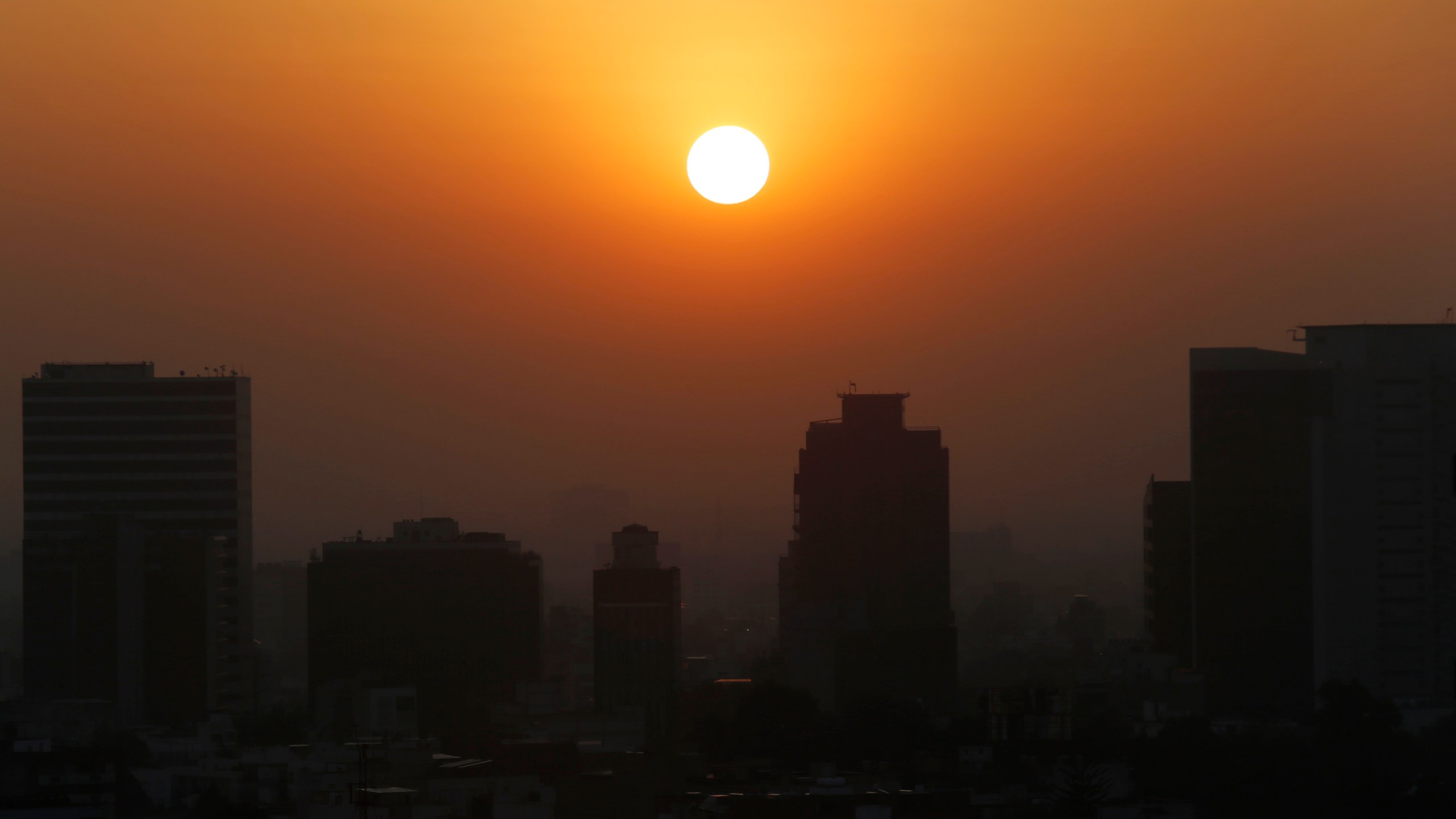 In this Thursday, Feb. 20, 2020 file photo, the sun rises amid smog during the dry season in Mexico City. Five years after a historic climate deal in Paris, world leaders are again meeting to increase their efforts to fight global warming. (AP Photo/Marco Ugarte)