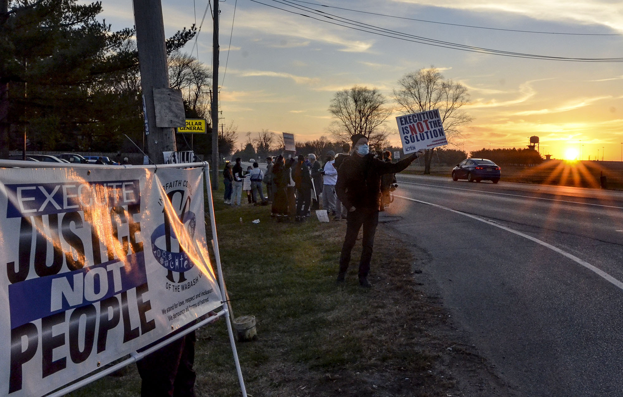 Protesters line Prairieton Road across from the Federal Death Chamber in Terre Haute, Ind., during a protest against the execution of Brandon Bernard on Thursday evening, Dec. 10, 2020. (Austen Leake/The Tribune-Star via AP)