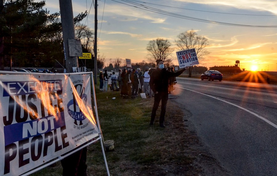 Protesters line Prairieton Road across from the Federal Death Chamber in Terre Haute, Ind., during a protest against the execution of Brandon Bernard on Thursday evening, Dec. 10, 2020. (Austen Leake/The Tribune-Star via AP)