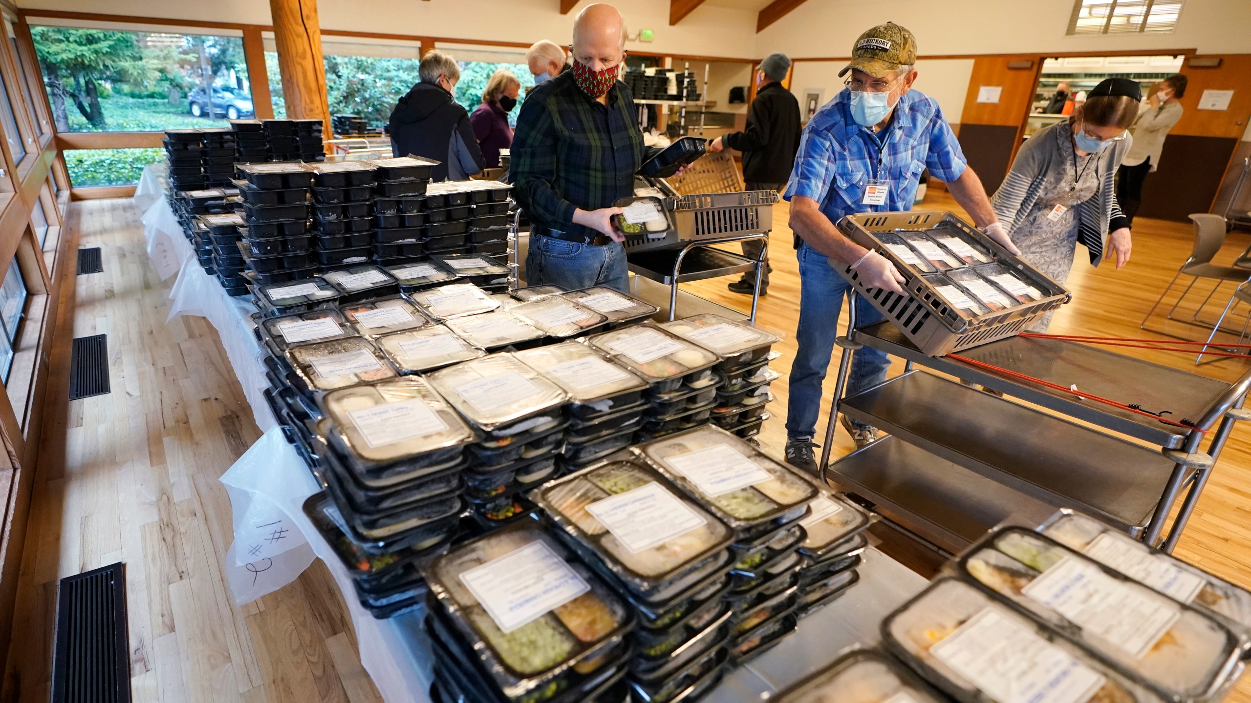 Meals on Wheels volunteers sort prepared meals prior to deliver to seniors, Wednesday, Dec. 9, 2020 at the Renton Senior Activity Center in Renton, Wash., south of Seattle. (Ted S. Warren/AP Photo)