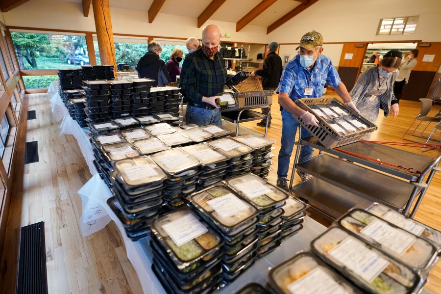 Meals on Wheels volunteers sort prepared meals prior to deliver to seniors, Wednesday, Dec. 9, 2020 at the Renton Senior Activity Center in Renton, Wash., south of Seattle. (Ted S. Warren/AP Photo)