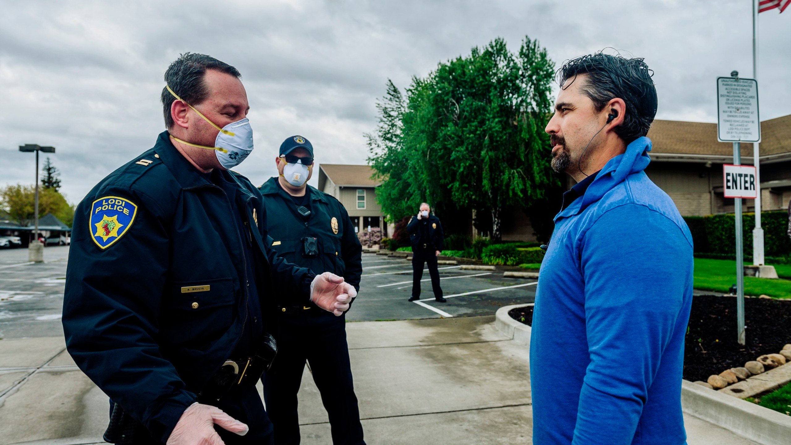 In this April 5, 2020, file photo, Lodi Police Capt. Sierra Brucia, left, meets with Pastor Jon Duncan of the Cross Culture Christian Center on Palm Sunday in Lodi, Calif. The church sued Gov. Gavin Newsom arguing his stay-at-home order violated their constitutional rights. In San Joaquin County, part of California's vast Central Valley that produces most of the country's fruits and vegetables, the coronavirus is the leading cause of death this year and things will only worsen as infections skyrocket and hospitals fill beyond capacity. Like most of California, the city of Lodi is under a broad shutdown order as Christmas approaches, and its residents and businesses are grappling with how to stay safe while keeping their economy operating. (Daniel Kim/The Sacramento Bee via AP)