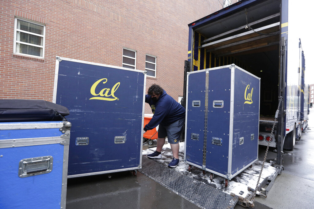 California equipment truck driver Dustin Sandoval loads equipment for his team into the trailer outside Martin Stadium after the NCAA college football game between Washington State and California was canceled on Dec. 12, 2020, in Pullman, Wash. (AP Photo/Young Kwak)