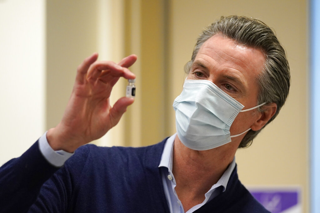 California Gov. Gavin Newsom holds up a vial of the Pfizer-BioNTech COVID-19 vaccine at Kaiser Permanente Los Angeles Medical Center on Dec. 14, 2020. (AP Photo/Jae C. Hong)