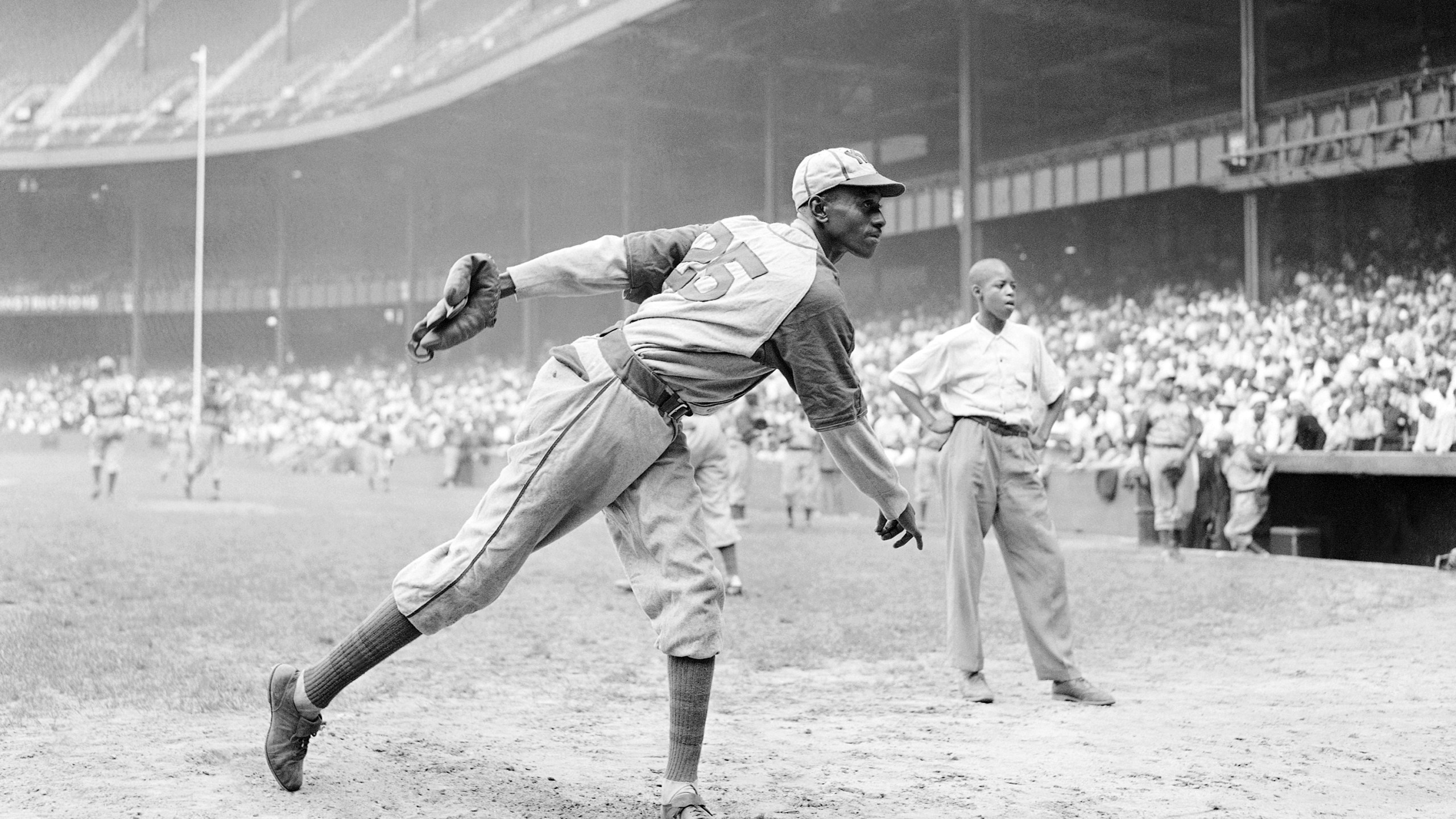 In this Aug. 2, 1942, file photo, Kansas City Monarchs pitcher Leroy Satchel Paige warms up at New York's Yankee Stadium before a Negro League game between the Monarchs and the New York Cuban Stars. Major League Baseball has reclassified the Negro Leagues as a major league and will count the statistics and records of its 3,400 players as part of its history. (Matty Zimmerman/ Associated Press File)