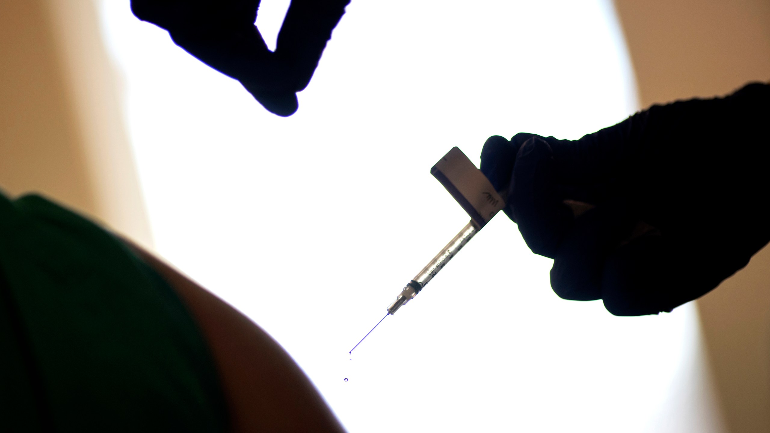 In this Tuesday, Dec. 15, 2020 file photo, a droplet falls from a syringe after a health care worker is injected with the Pfizer-BioNTech COVID-19 vaccine at Women & Infants Hospital in Providence, R.I. (AP Photo/David Goldman, File)