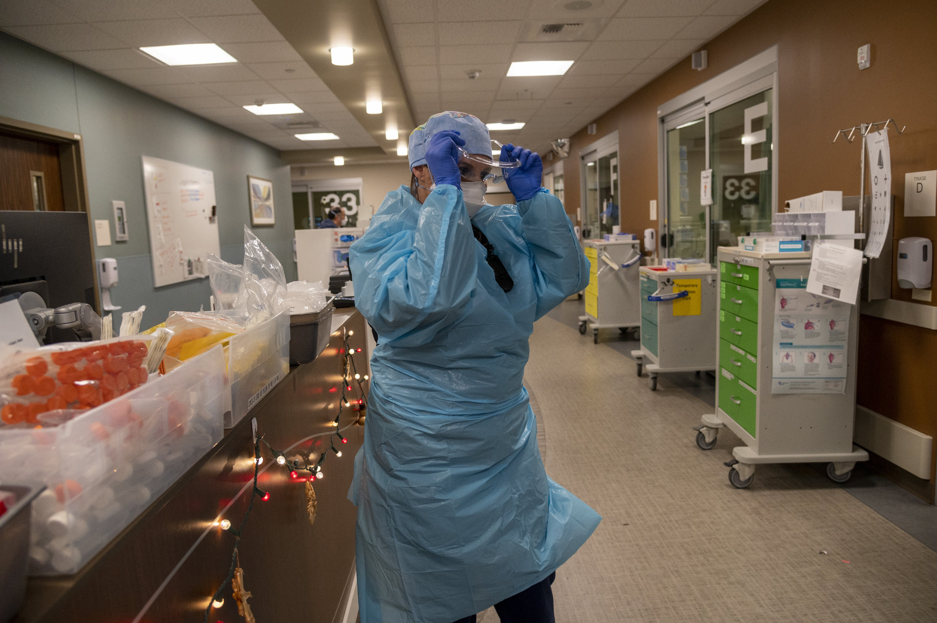 Registered Nurse Allison Shiftar puts on protective glasses as she gets ready to go into one of the triage rooms to care for a COVID-19 positive patient in the emergency department at Sutter Roseville Medical Center in Roseville, Calif. on Dec. 22, 2020. (Renee C. Byer/The Sacramento Bee via AP, Pool)