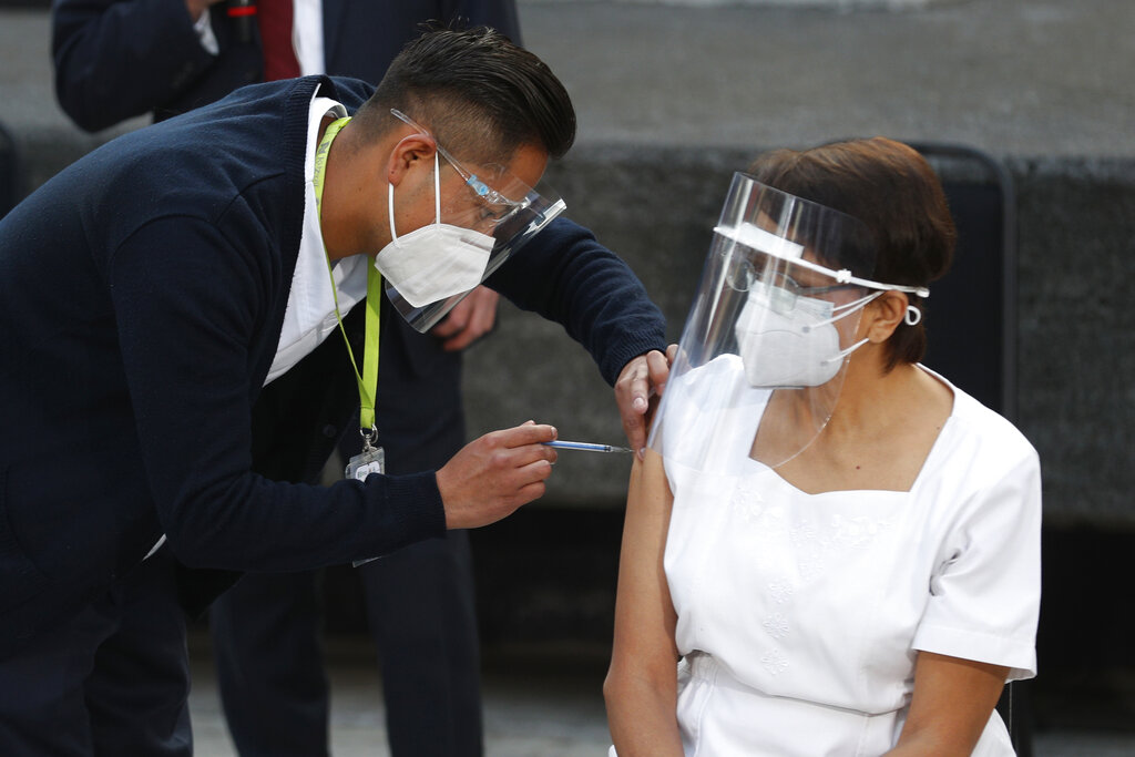 Health worker Maria Ramírez is the first to get vaccinated for COVID-19 at the General Hospital in Mexico City, early on Dec. 24, 2020.(AP Photo/Eduardo Verdugo)