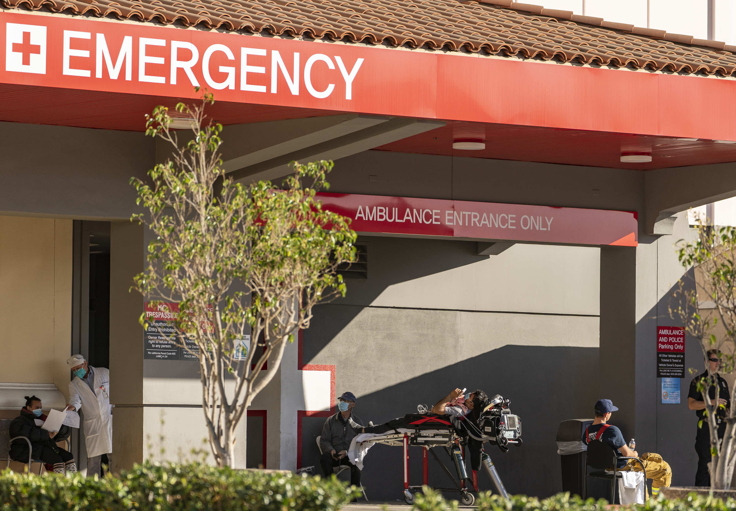 In this Dec. 18, 2020 file photo an unidentified patient receives oxygen on a stretcher, while Los Angeles Fire Department Paramedics monitor him outside the Emergency entrance, waiting for admission at the CHA Hollywood Presbyterian Medical Center in Los Angeles. (Damian Dovarganes/AP Photo)