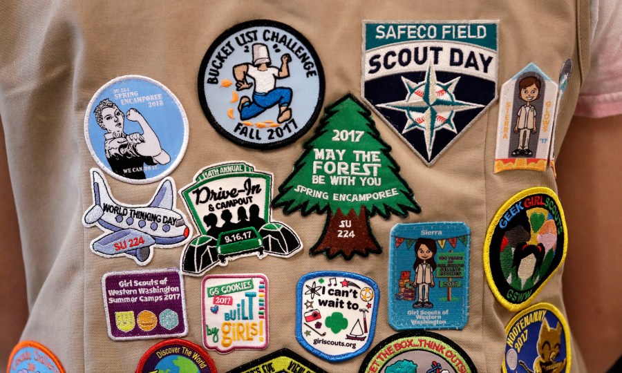 In this June 18, 2018, file photo, patches cover the back of a Girl Scout's vest at a demonstration of some of their activities in Seattle. (Elaine Thompson/AP Photo)