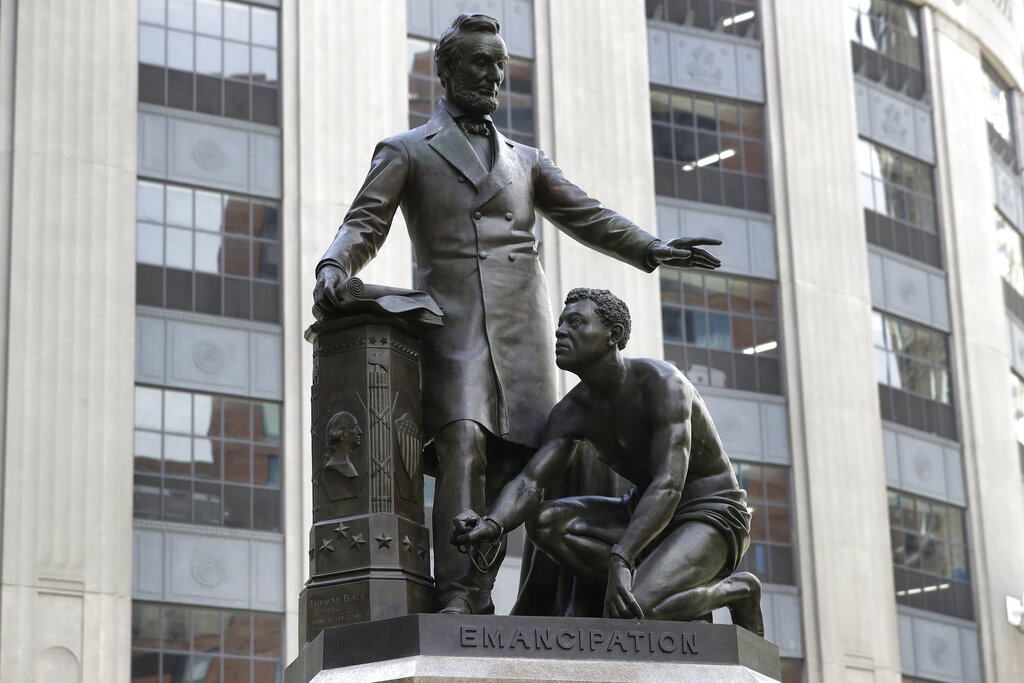 In this June 25, 2020, file photo, a statue that depicts a freed slave kneeling at President Abraham Lincoln's feet rests on a pedestal in Boston. On Tuesday, Dec. 29, the statue that drew objections amid a national reckoning with racial injustice was removed from its perch. (AP Photo/Steven Senne, File)