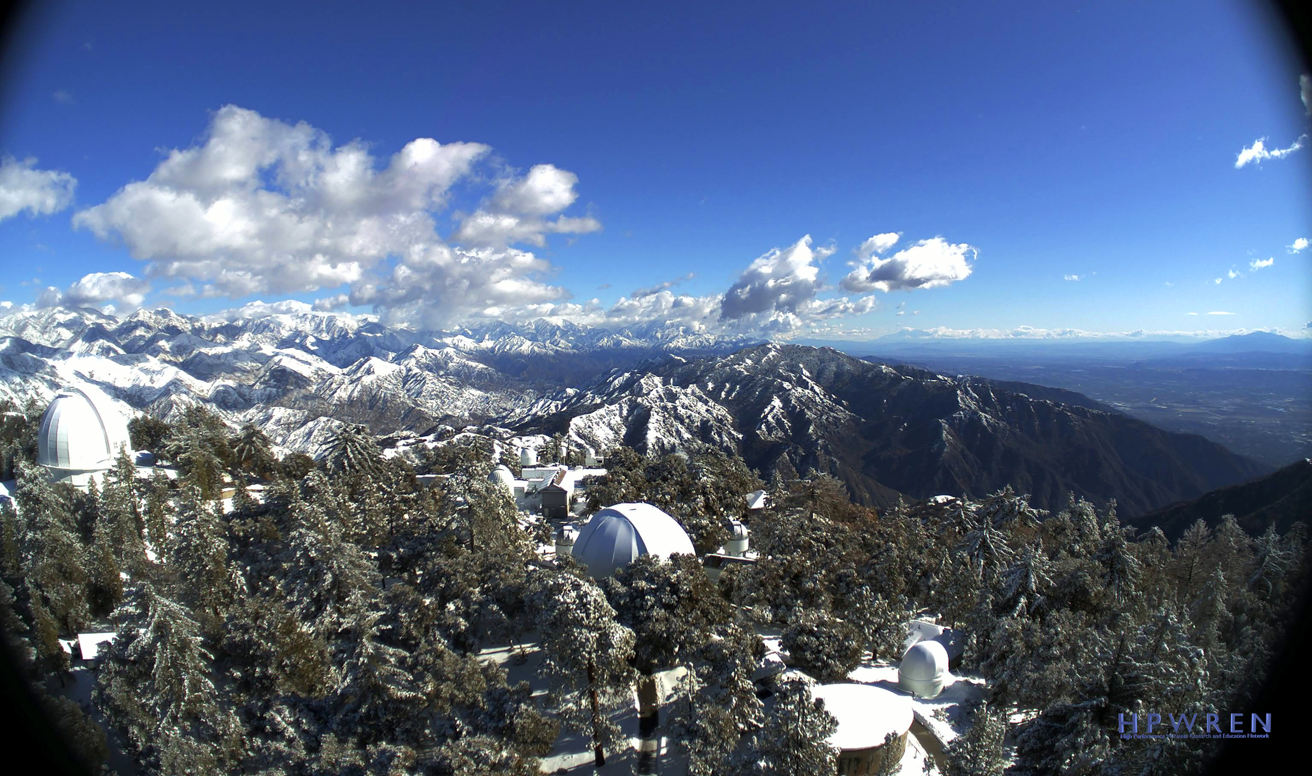 This photo provided by High Performance Wireless Research and Education Network (HPWREN) from a remote camera atop Mount Wilson shows the snow-capped San Gabriel Mountains beyond the famous observatory cluster north of Los Angeles Tuesday, Dec. 29, 2020. (HPWREN via AP)