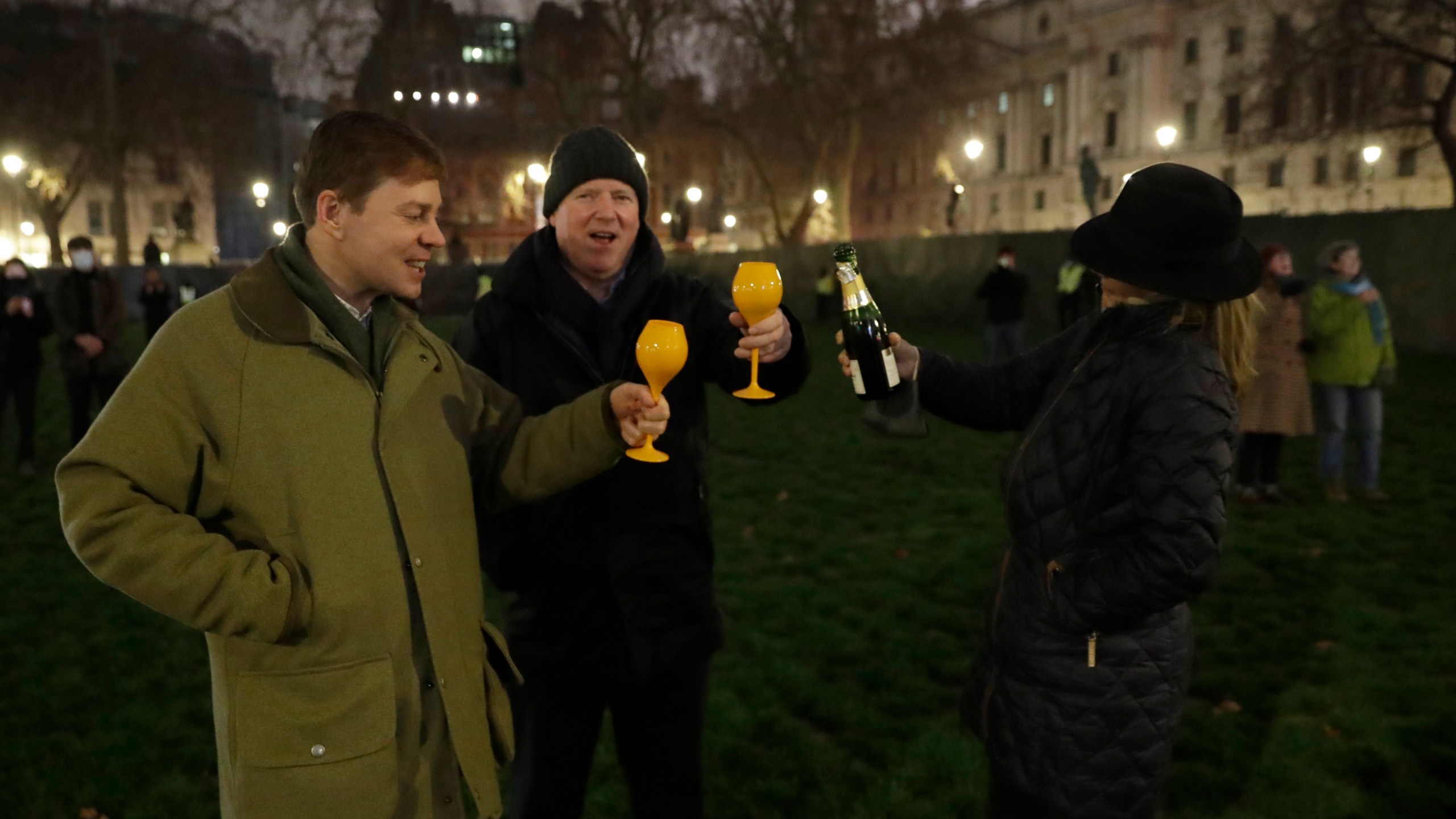 People raise a glass and celebrate in Parliament Square as the bell known as Big Ben strikes 2300, and Britain ends its transition period and formally leaves the European Union on Dec. 31, 2020. (Matt Dunham/Associated Press)