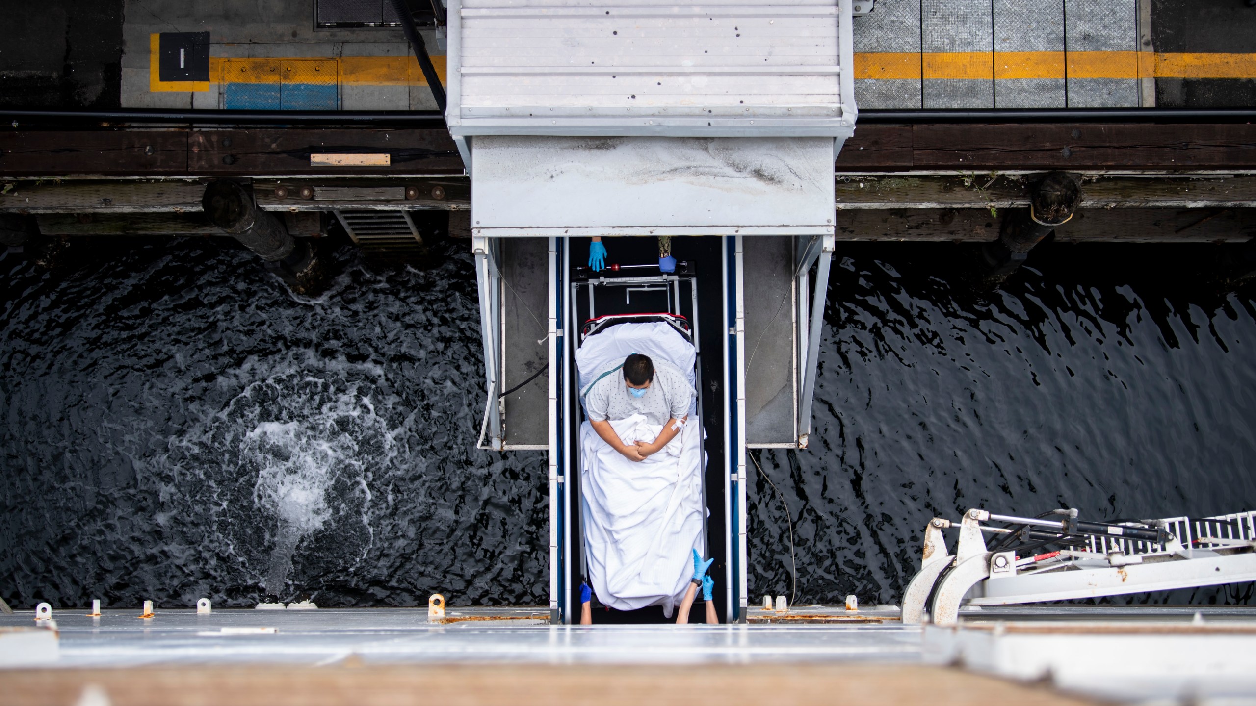 In this handout released by the U.S. Navy, Sailors transport a patient across the brow to be admitted aboard the hospital ship USNS Mercy (T-AH 19) on April 6, 2020 in Los Angeles, California. (Ryan Breeden/U.S. Navy via Getty Images)