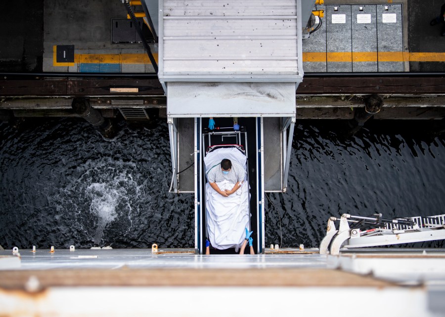 In this handout released by the U.S. Navy, Sailors transport a patient across the brow to be admitted aboard the hospital ship USNS Mercy (T-AH 19) on April 6, 2020 in Los Angeles, California. (Ryan Breeden/U.S. Navy via Getty Images)