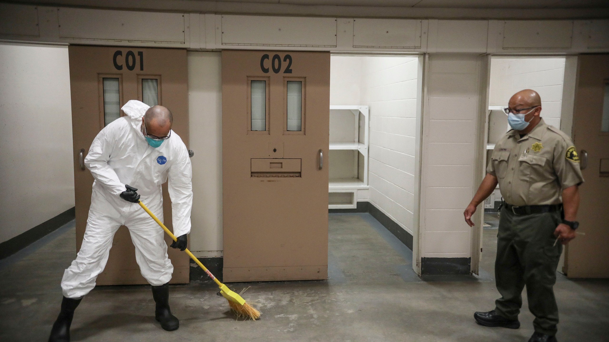 A Sheriff's deputy overlooks an inmate sweeping at the San Diego County Jail on April 24, 2020 in San Diego, California. (Sandy Huffaker/Getty Images)