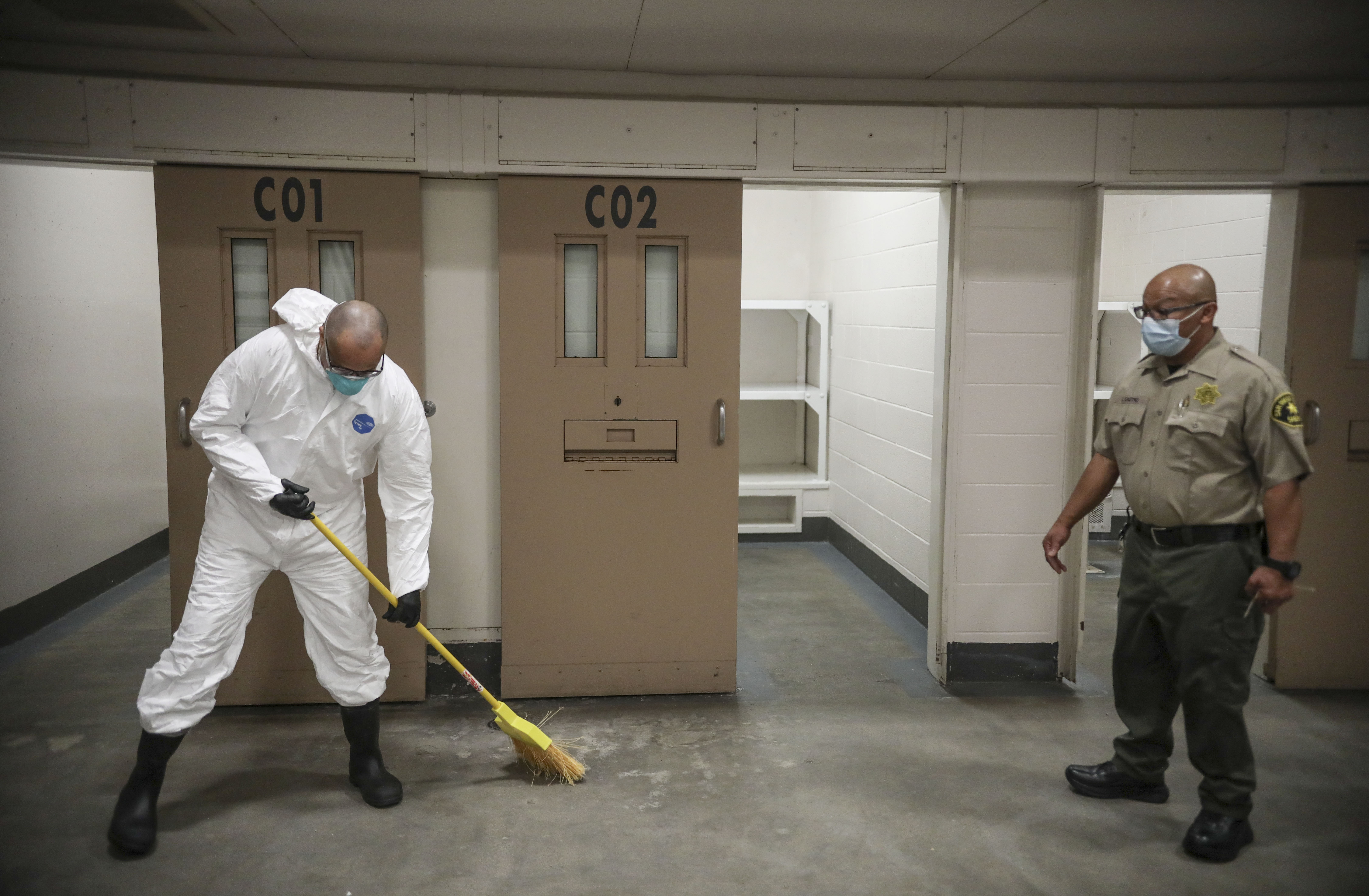 A Sheriff's deputy overlooks an inmate sweeping at the San Diego County Jail on April 24, 2020 in San Diego, California. (Sandy Huffaker/Getty Images)