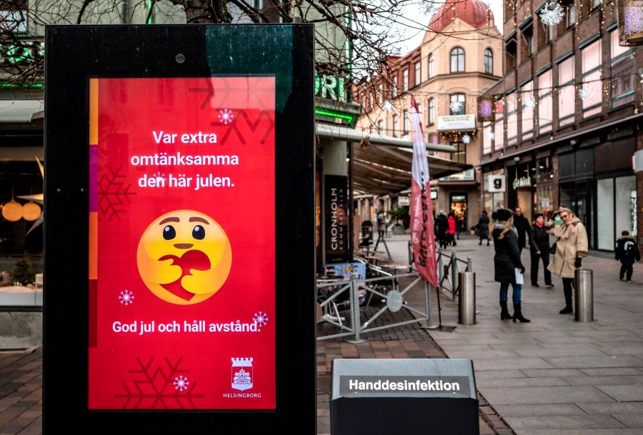 An information sign wishing Merry Christmas and asking to maintain social distancing is seen in a pedestrian shopping street in Helsingborg, southern Sweden, on December 7, 2020. (JOHAN NILSSON/TT News Agency/AFP via Getty Images)