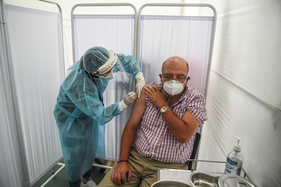 A health worker inoculates a volunteer with a COVID-19 vaccine produced by the Chinese Sinopharm during its trial at the Clinical Studies Center of the Cayetano Heredia University in Lima on Dec. 9, 2020. (ERNESTO BENAVIDES/AFP via Getty Images)